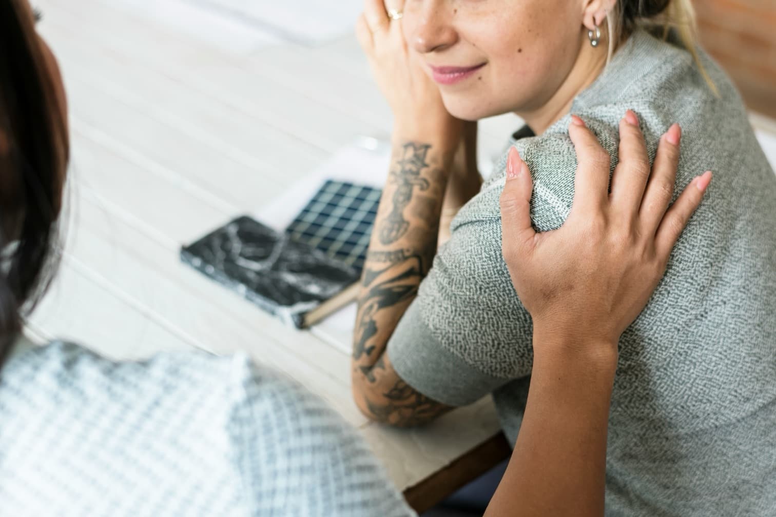 Une responsable RH pose la main sur l'épaule d'une collaboratrice lors d'un entretien individuel